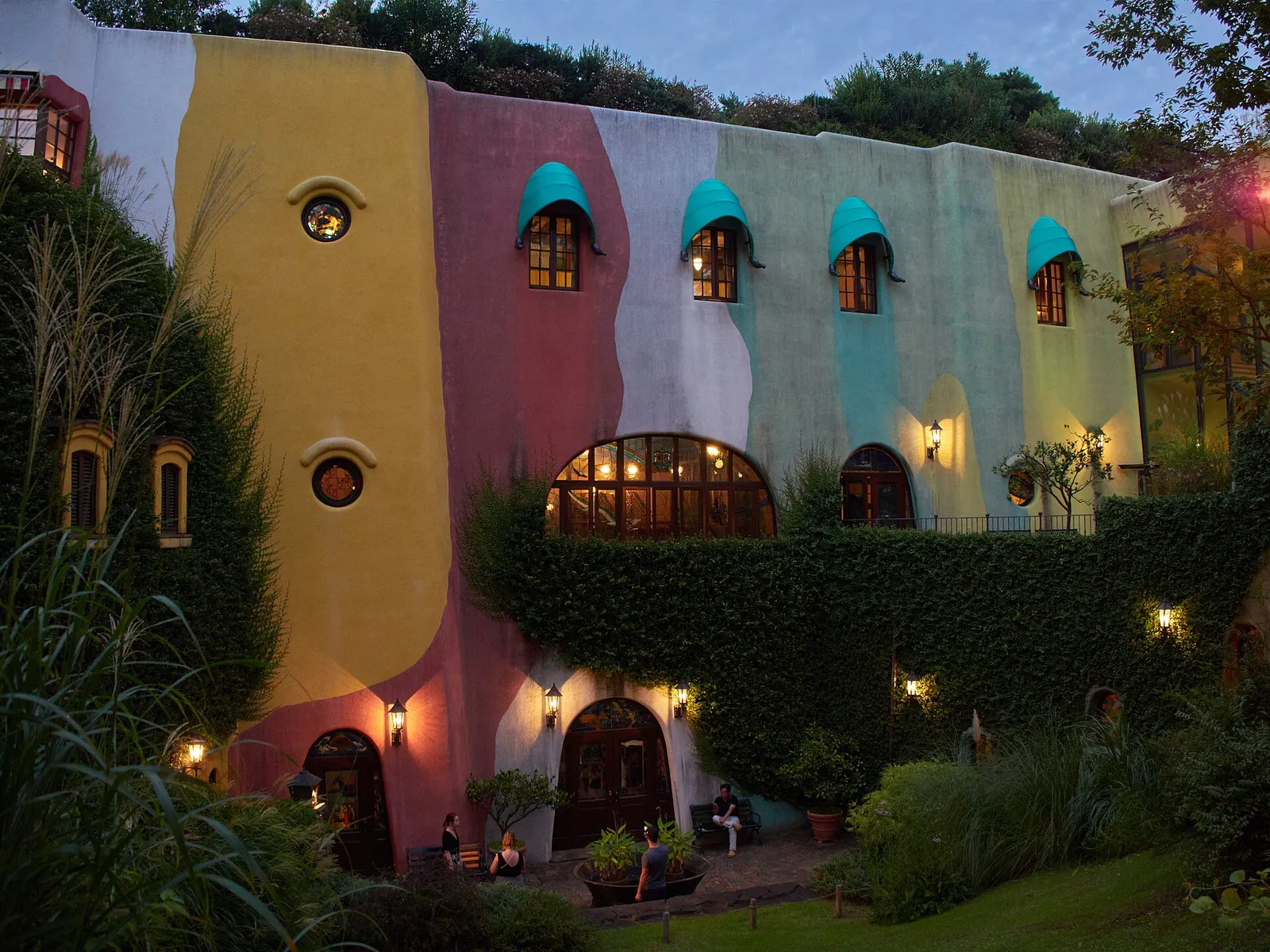 The whimsical, colourful ivy-covered exterior of the Ghibli Museum in Mitaka, Tokyo, at dusk.
