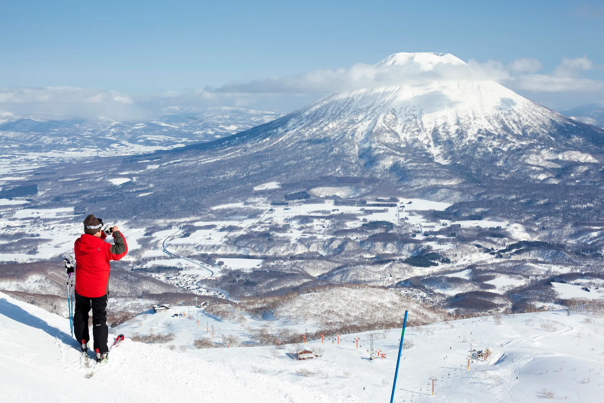 A skier on the slopes of Niseko looking out over the perfectly conical, snow-covered Mount Yōtei in Hokkaido.